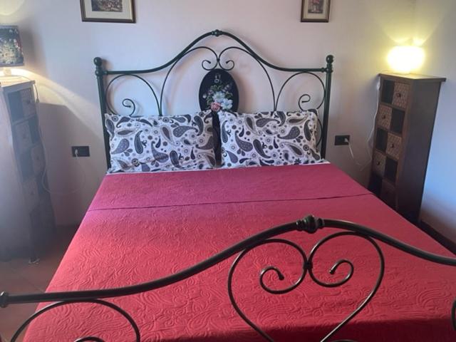 um quarto com uma cama grande e um cobertor vermelho em SHARON HOUSE NEAR THE MALL OUTLET em Incisa in Valdarno