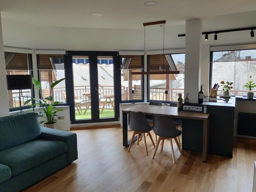 eine Küche und ein Wohnzimmer mit einem Tisch und einem Sofa in der Unterkunft Modern top floor loft with balcony in Budapest