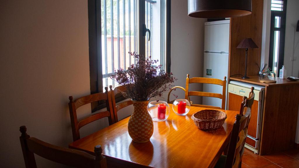 una mesa de madera con un jarrón con flores. en Casa Rural Valle de los Molinos, en El Cristo del Espíritu Santo