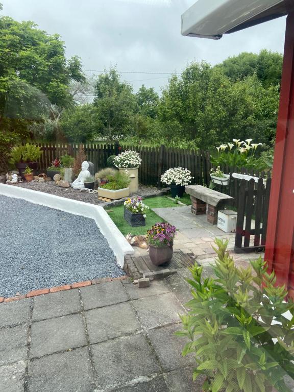 a garden with a bench and flowers in a yard at Barrow Harbour studio apartment in Tralee