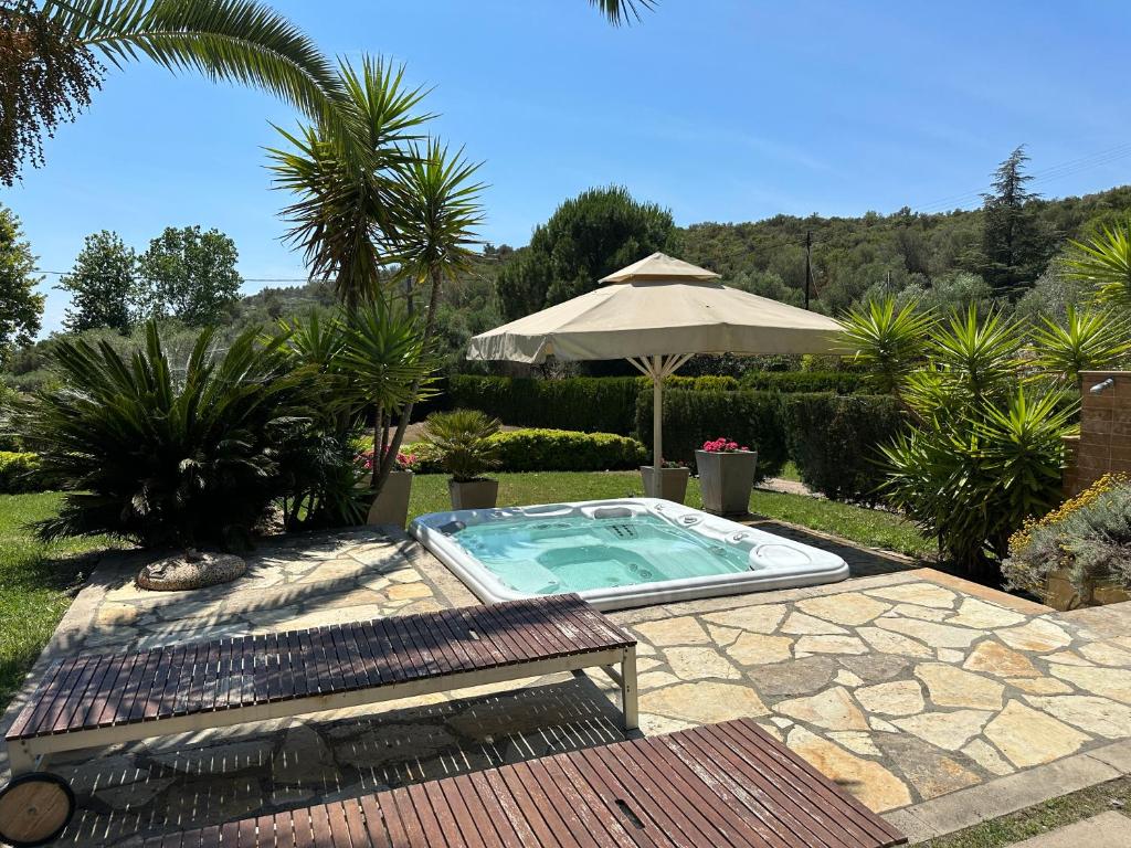 a swimming pool in a yard with an umbrella at Escape to Paradise Experience Luxury and Serenity at Villa Elina in Sithonia in Metókhion Ayías Kiriakís