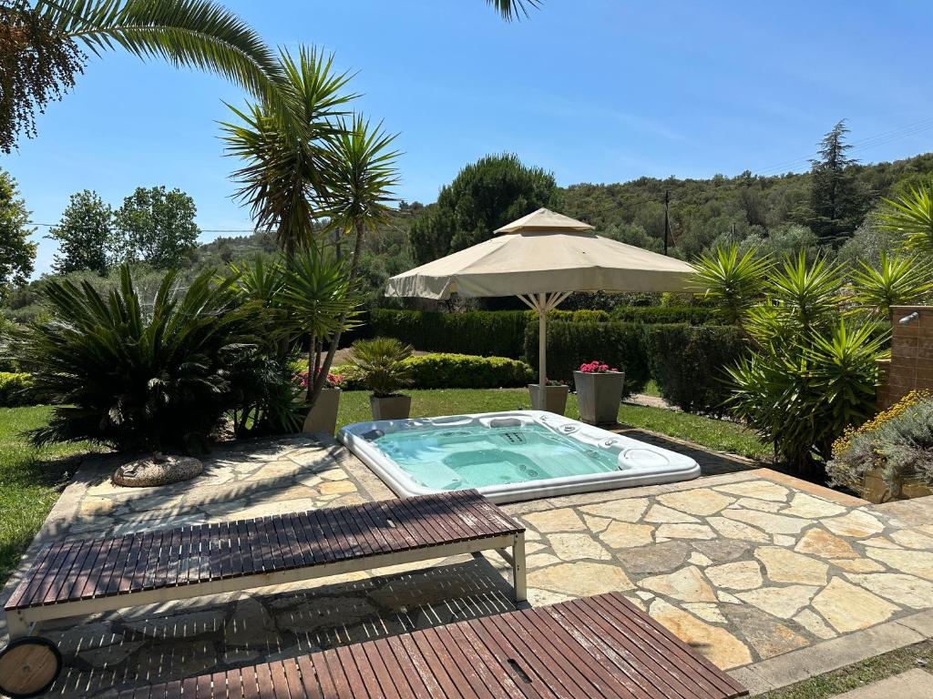 a swimming pool in a yard with an umbrella at Escape to Paradise - Experience Luxury and Serenity at Villa Elina in Sithonia in Metókhion Ayías Kiriakís