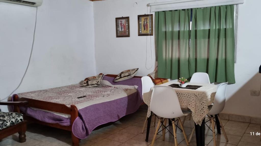 a bedroom with two beds and a table and chairs at Departamento monoambiente vacacional in Posadas