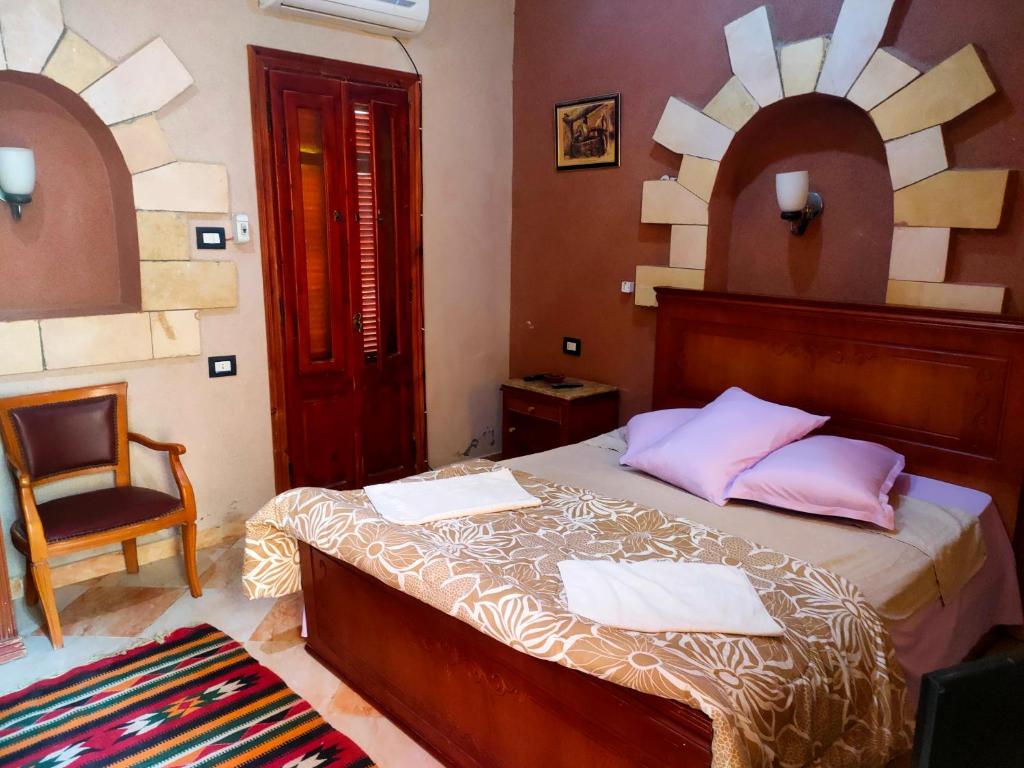a bedroom with a bed with a chair and a mirror at Panta Lodge Siwa بنتا لودج سيوة in Siwa