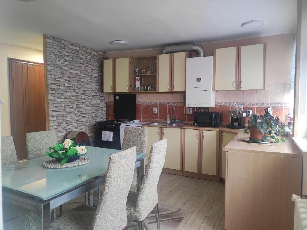 a kitchen with a table and chairs and a table and a counter at City Centre Apartament in Sarajevo