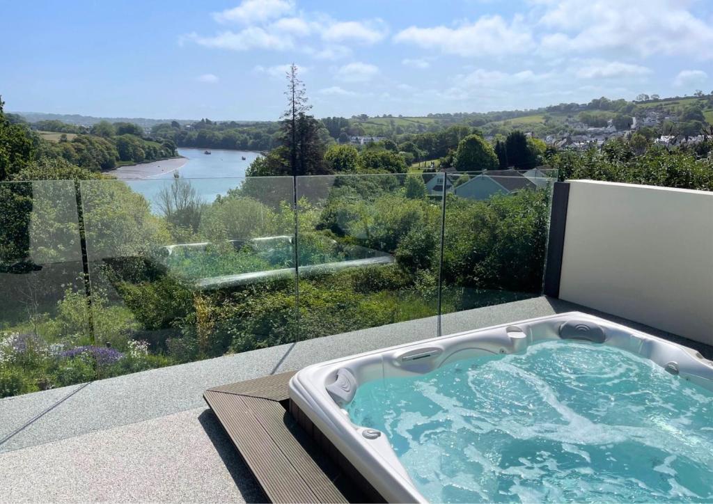 a jacuzzi tub on a balcony with a view at Gwbert Holiday Cottages, Green Meadow in Cardigan