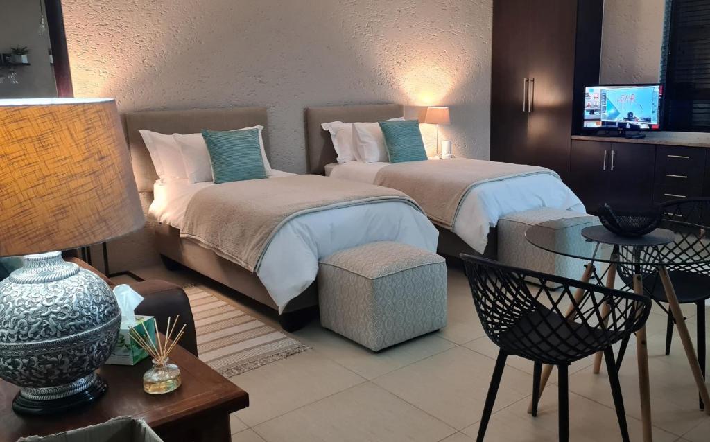 a hotel room with two beds and a television at One85 in Vinko in Pretoria