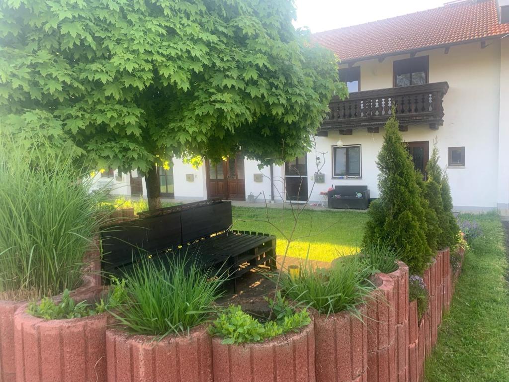 un banco en un patio frente a una casa en Ferienwohnung am Ponyhof, en Altötting