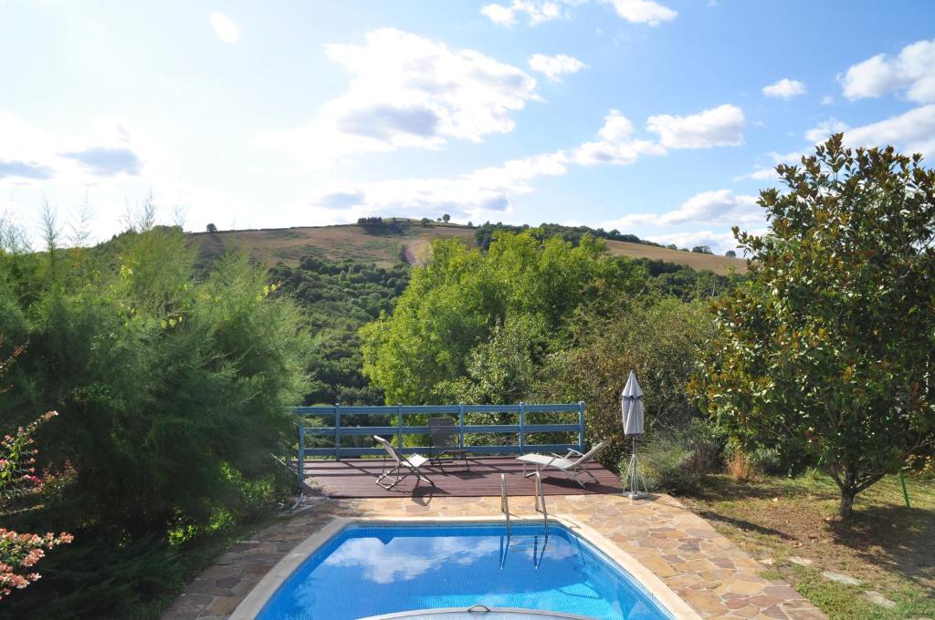 a swimming pool in a garden with a hill in the background at CHEZ LUCIEN in Trébas