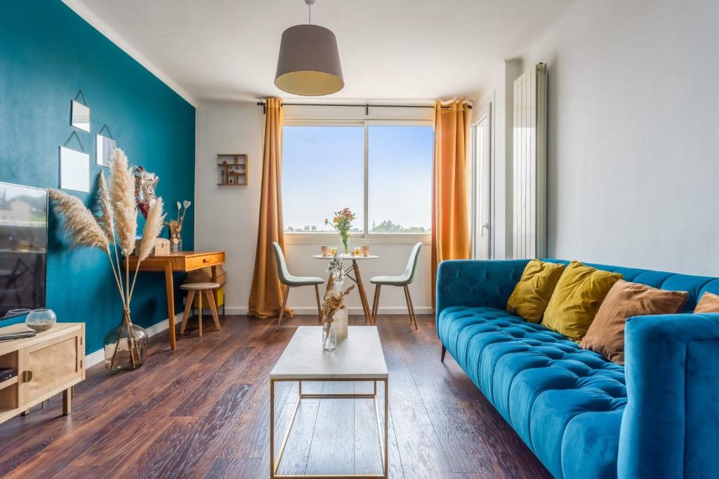 een woonkamer met een blauwe bank en een tafel bij Modern and colourful apartment with balcony - Montpellier - Welkeys in Montpellier