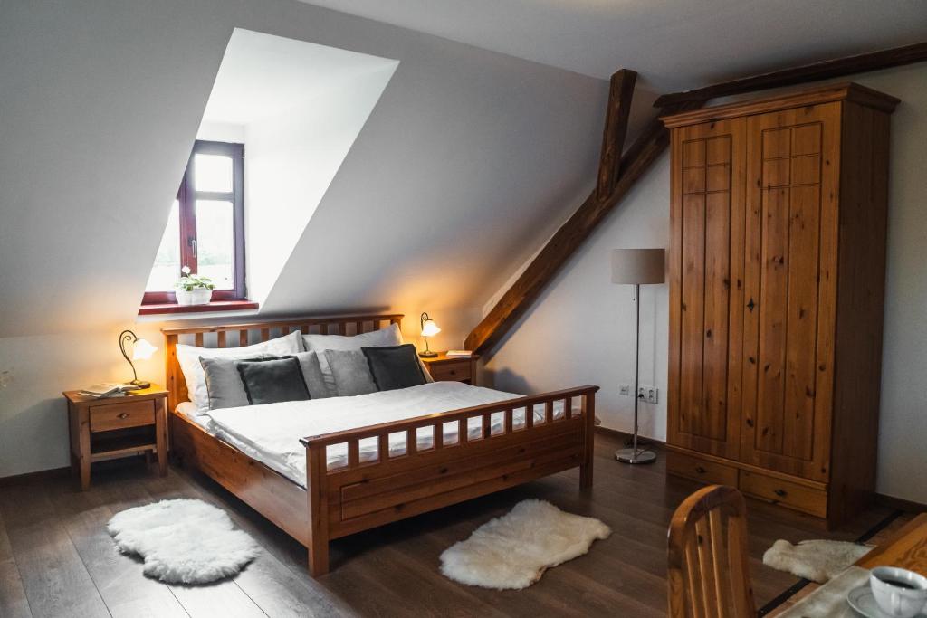 a bedroom with a wooden bed and a skylight at Penzion Apartmány Hetlín in Černíny