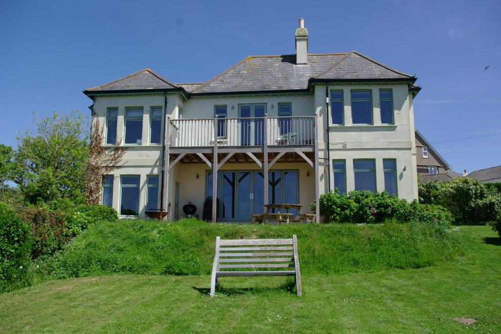 ławka przed dużym domem w obiekcie White Horses a large family home in Bantham South Devon with fantastic sea views w mieście Bigbury-on-Sea
