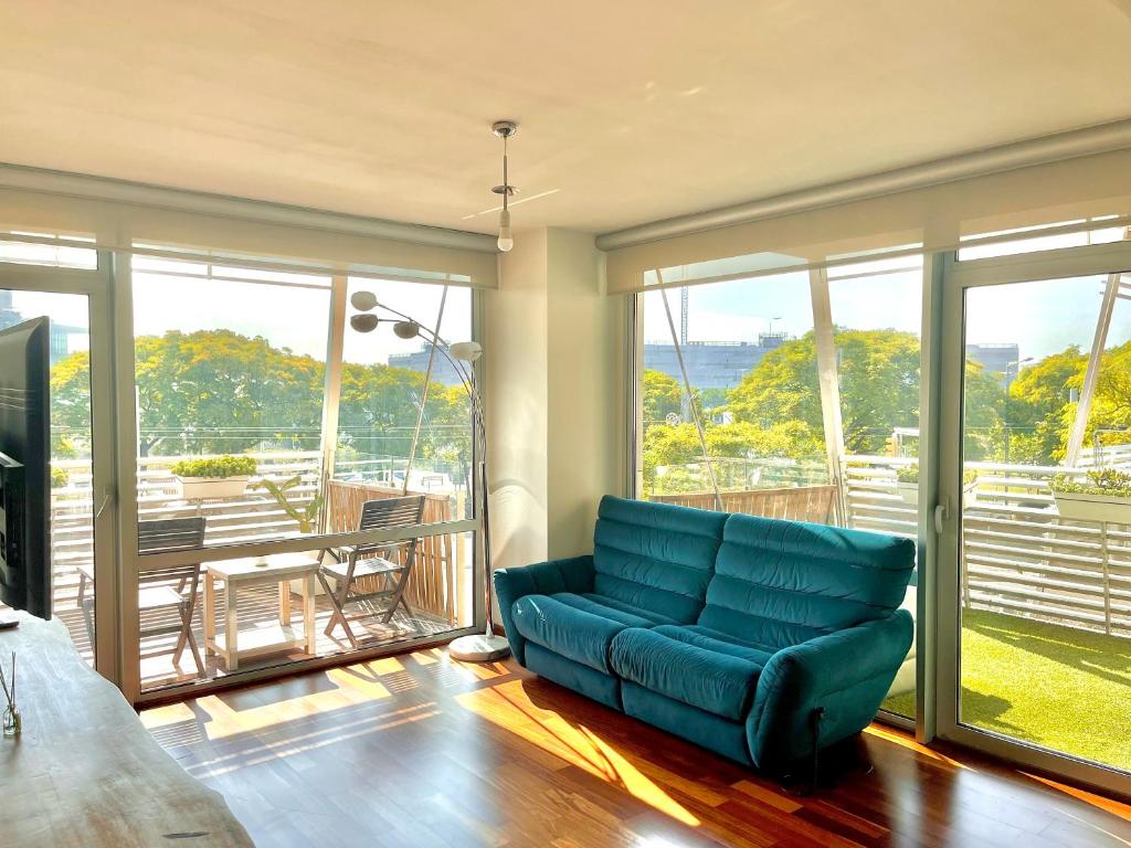 a living room with a blue couch in front of windows at SMLuxuryHouse in Barcelona