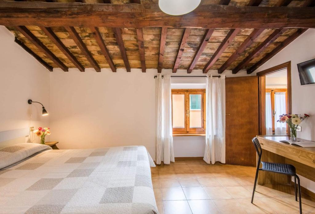 sypialnia z łóżkiem i drewnianym sufitem w obiekcie Albergo Dal Fata w mieście Gambassi Terme