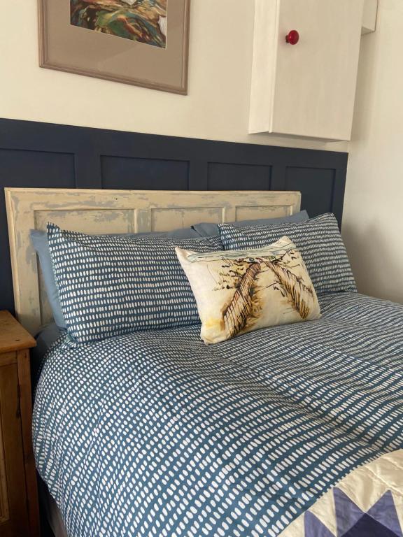 a bed with blue and white sheets and pillows at Barrow Harbour studio apartment in Tralee