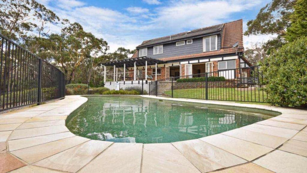 a house with a swimming pool in front of a house at The Manor in Blue Mountains in Wentworth Falls