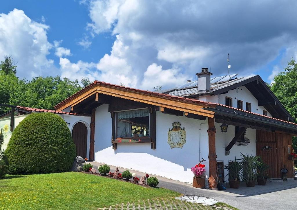 ein weißes Haus mit einem Gameradach in der Unterkunft Haus Silbertann in Schönau am Königssee