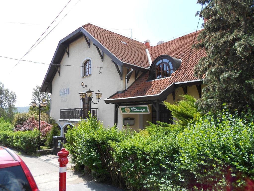 un edificio bianco con un idrante rosso davanti di Peregrino Panzió a Budaörs
