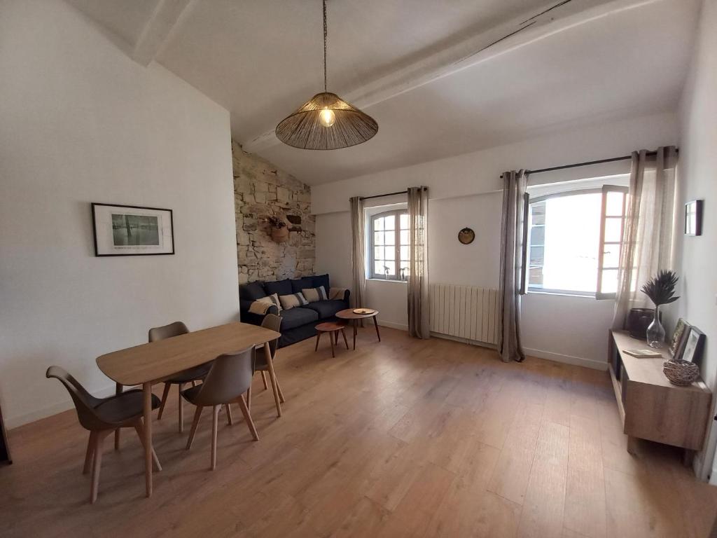 a living room with a table and chairs at Coeur d'Uzès in Uzès