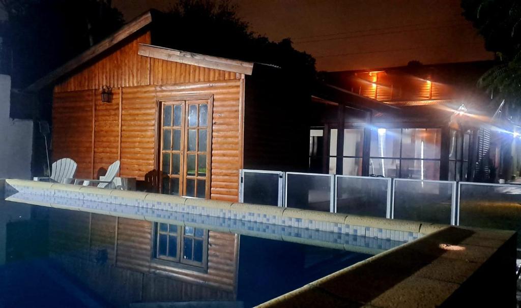 dom z basenem w nocy w obiekcie Cabaña Jano w mieście Posadas