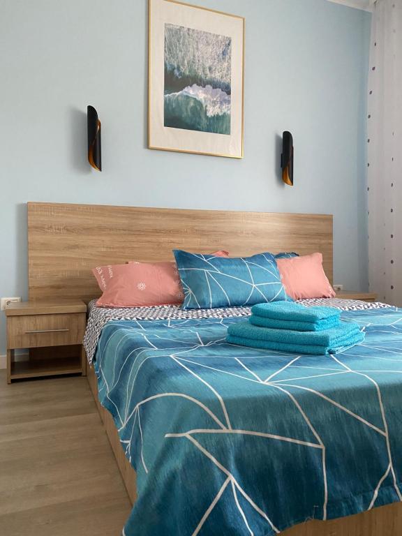 una camera da letto con un letto con cuscini blu e rosa di Perfect Holiday Villa a Constanţa