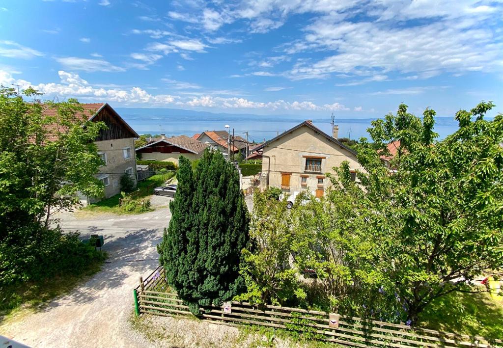 wioska z domem, ogrodzeniem i drzewami w obiekcie Maison familiale vue lac avec jardin - à 10mn du lac et stations de ski w mieście Publier