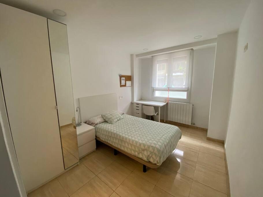 een slaapkamer met een bed, een wastafel en een raam bij Apartment in Bilbao, comfortable and well equipped in Bilbao