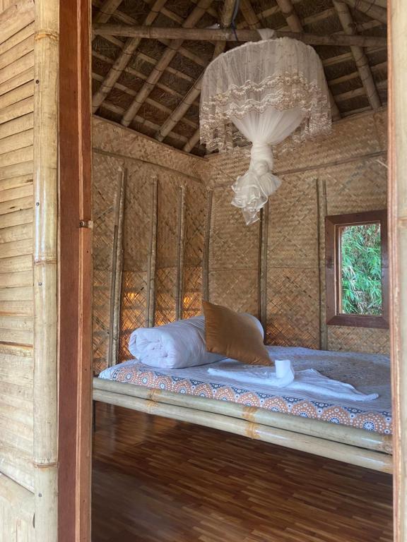 Bett in einem Zimmer mit Kronleuchter in der Unterkunft Happy Lemon Tree lodge in Sauraha