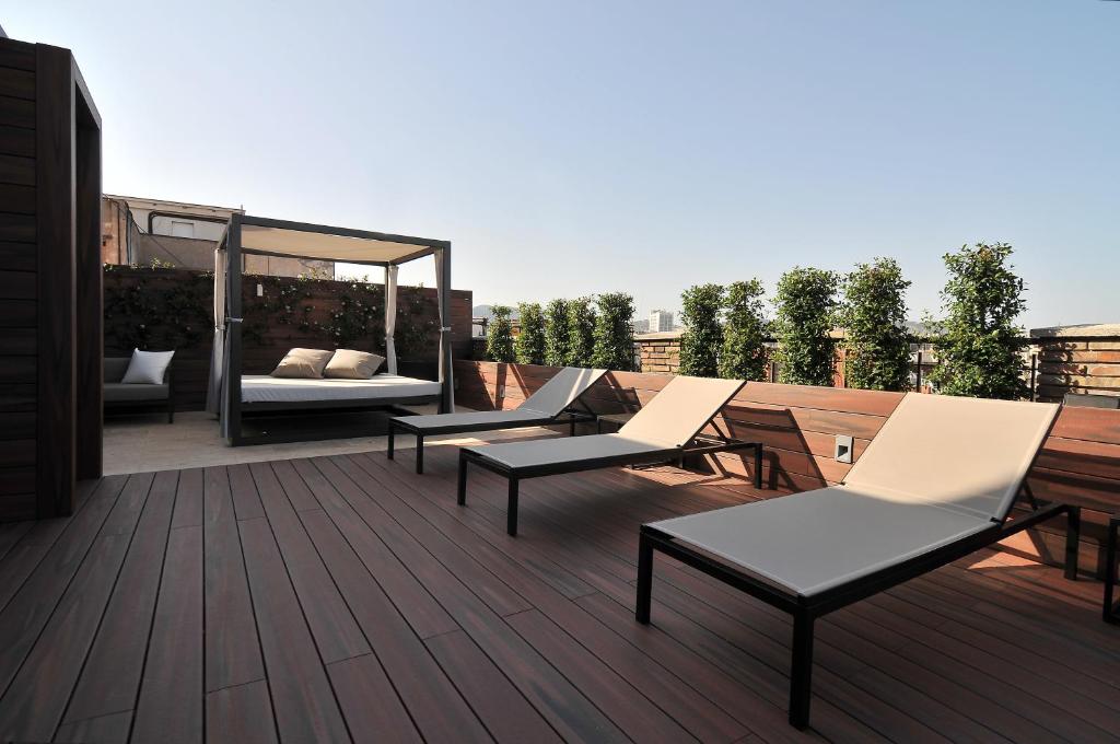 a rooftop deck with chairs and a gazebo at U232 Hotel in Barcelona