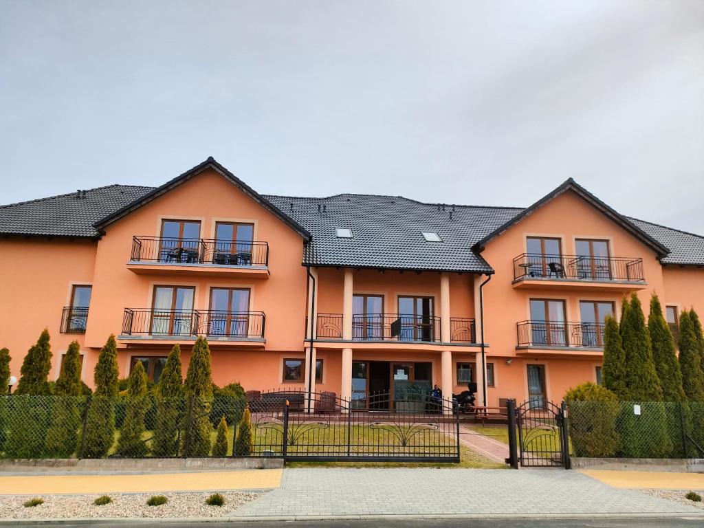 a large orange house with a black roof at Pensjonat Złoto Bałtyku in Łeba