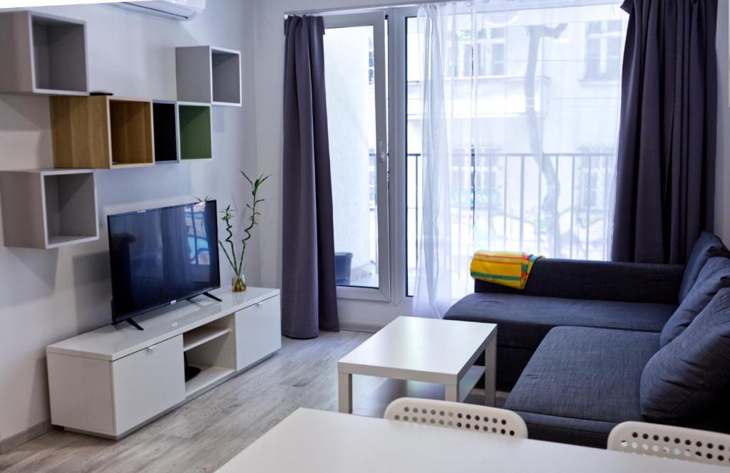 a living room with a couch and a tv at Old town 1 bdr, A/C, w/parking in Bratislava