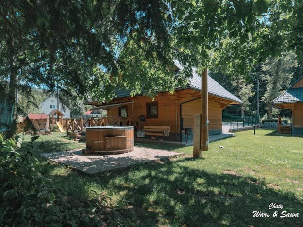 a log cabin with a hot tub in the yard at Drevenice Wars & Sawa in Oščadnica
