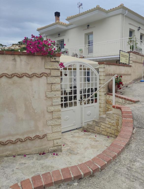 a gate to a house with pink flowers at Cruzeto in Syvota
