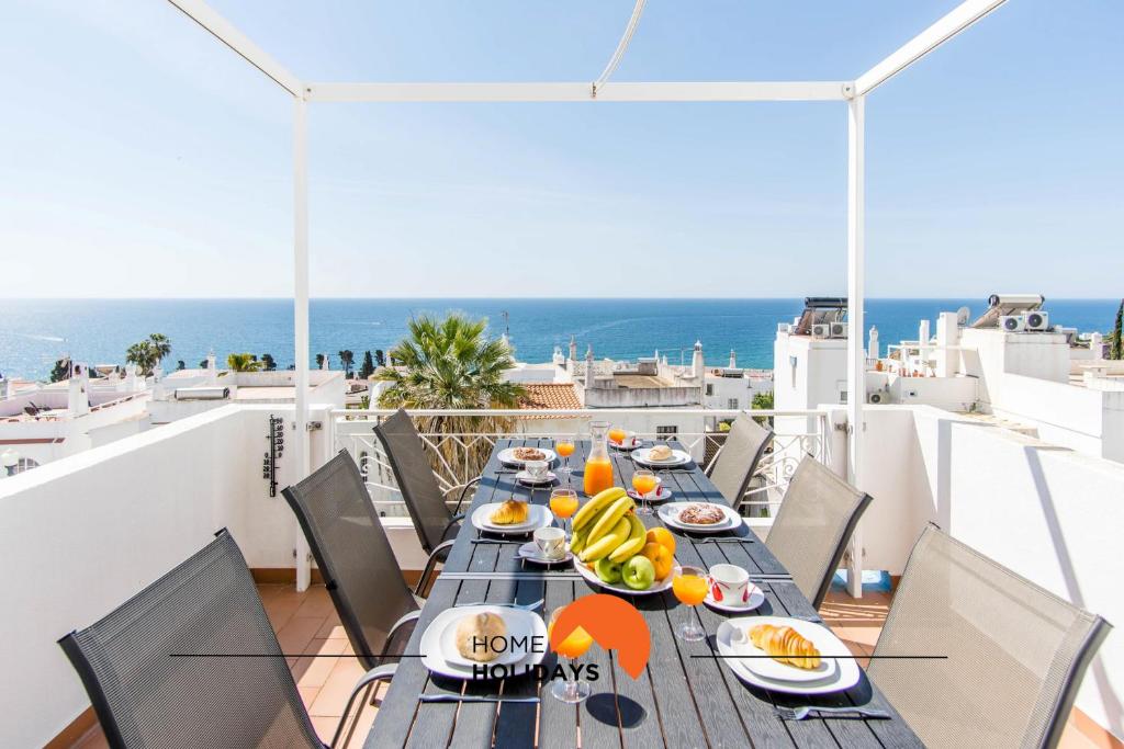 a table with food on top of a balcony with the ocean at #052 V4 Mimosas by Home Holidays in Páteo