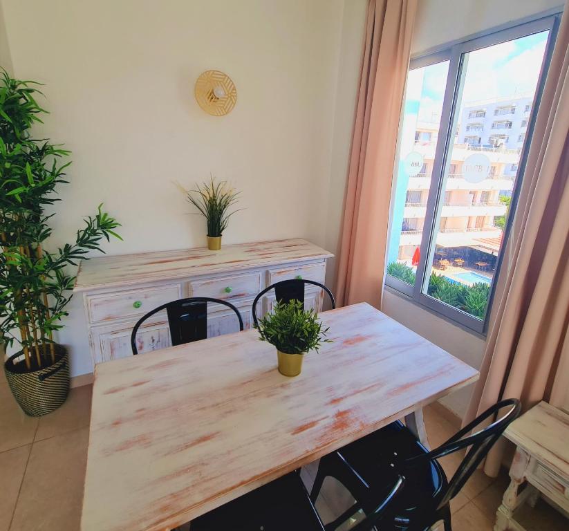 a dining room with a table and chairs and a window at Tabbu ibiza apartments in Playa d'en Bossa