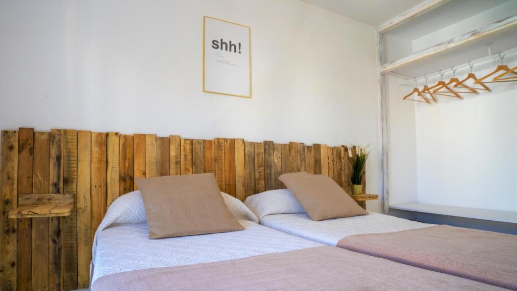 a bedroom with two beds with wooden walls at Tabbu ibiza apartments in Playa d'en Bossa