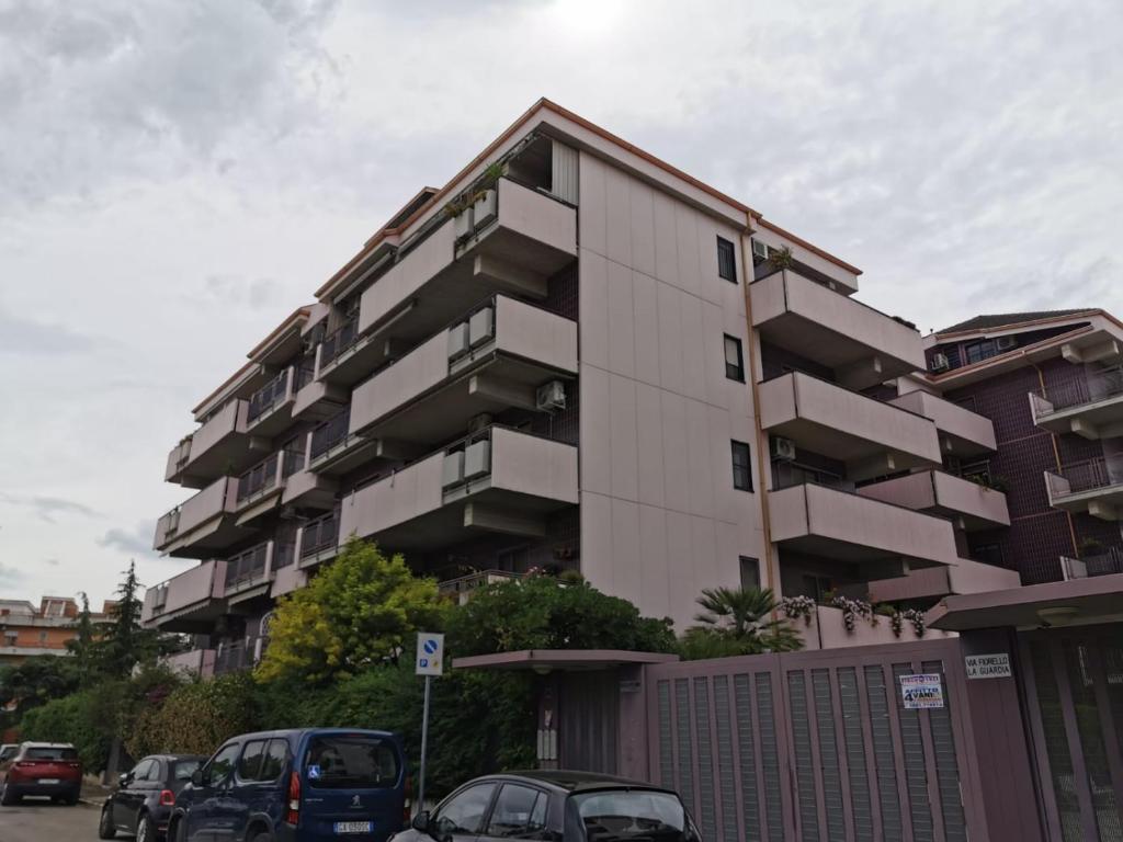 a tall building with cars parked in front of it at NSM La Vie en Rose appartamento con box e terrazzo in Foggia