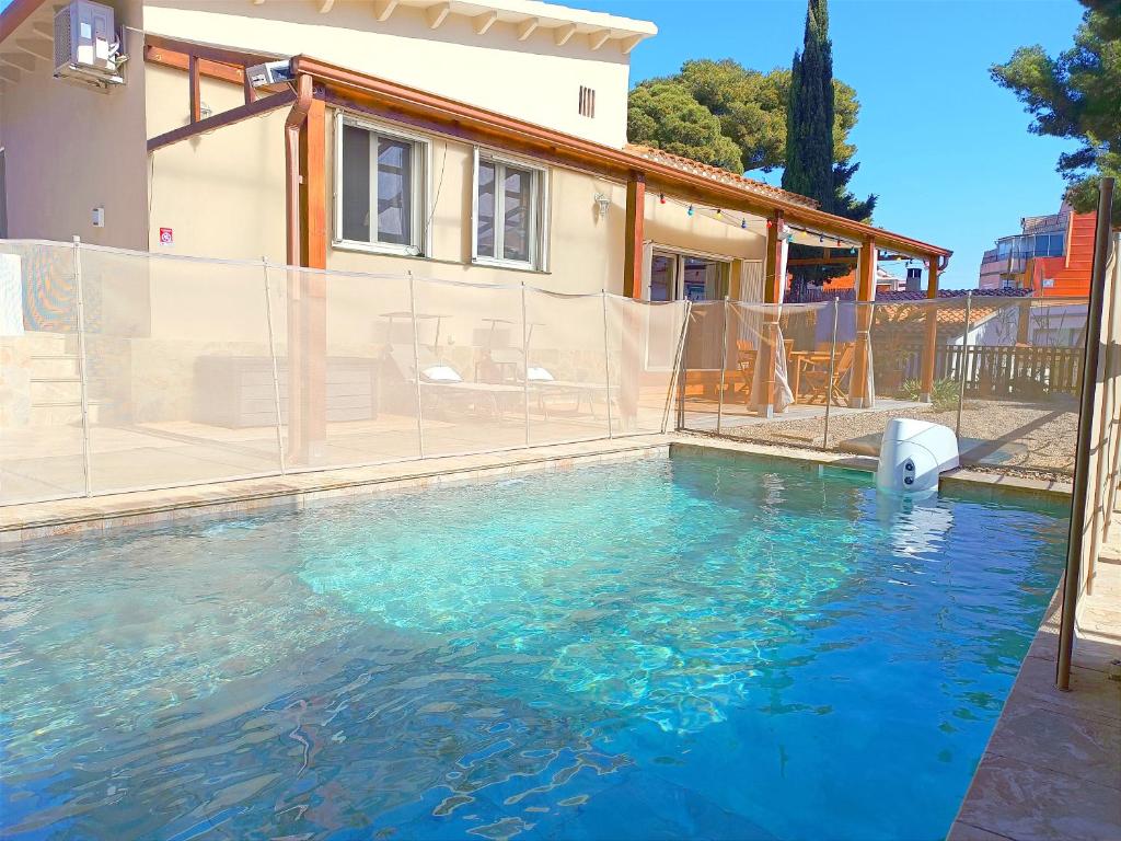 a swimming pool with blue water in front of a house at House with pool near Park Guell in Barcelona
