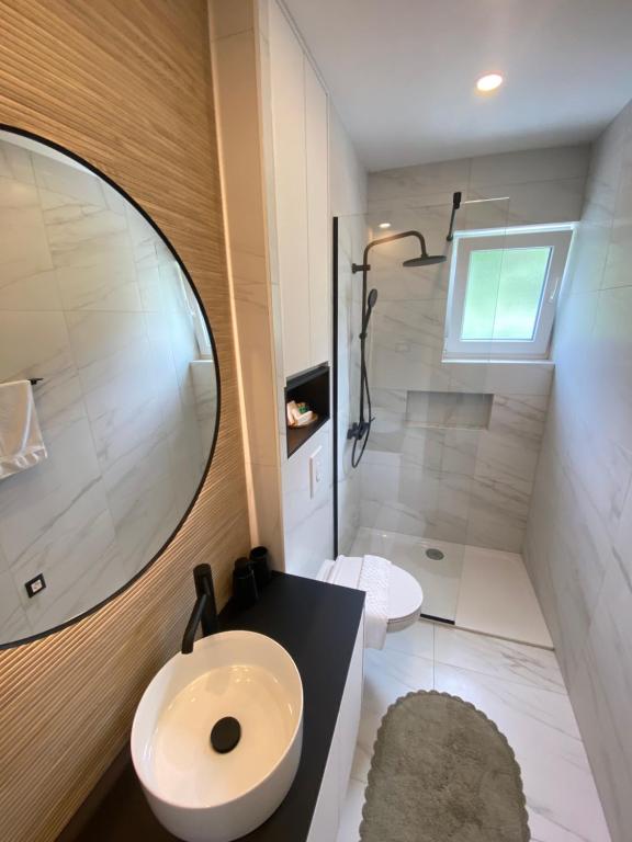 a bathroom with a sink and a toilet and a mirror at Mediteran in Tučepi