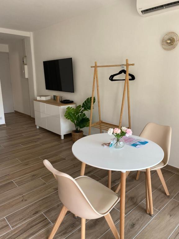 a living room with a table and chairs and a tv at Mistral gagnant - parking privé in Cassis