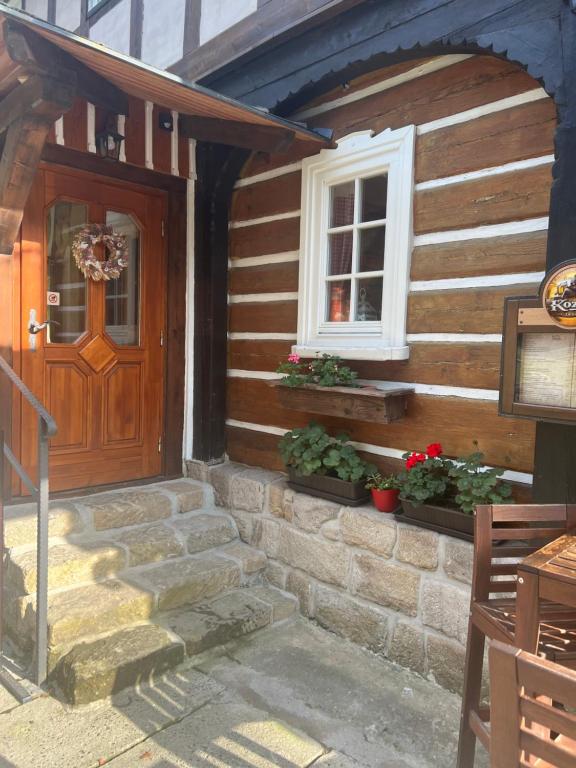 ein Haus mit einer Holztür und einem Fenster in der Unterkunft Pension Soutěsky in Hřensko