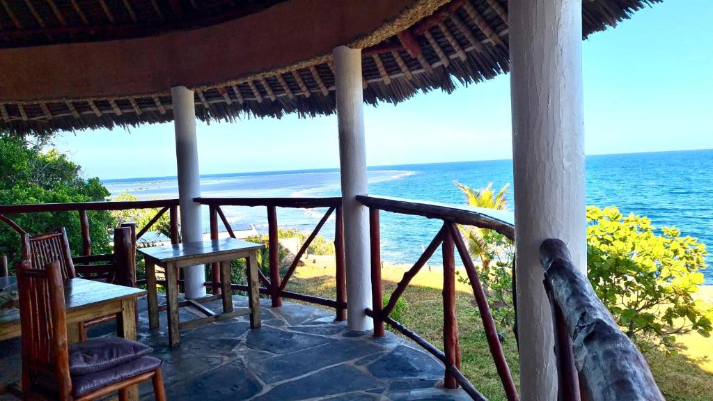 a porch with chairs and a view of the ocean at Room in Villa - A 37m2 suite in a 560 m2 Villa, Indian Ocean View in Shimoni
