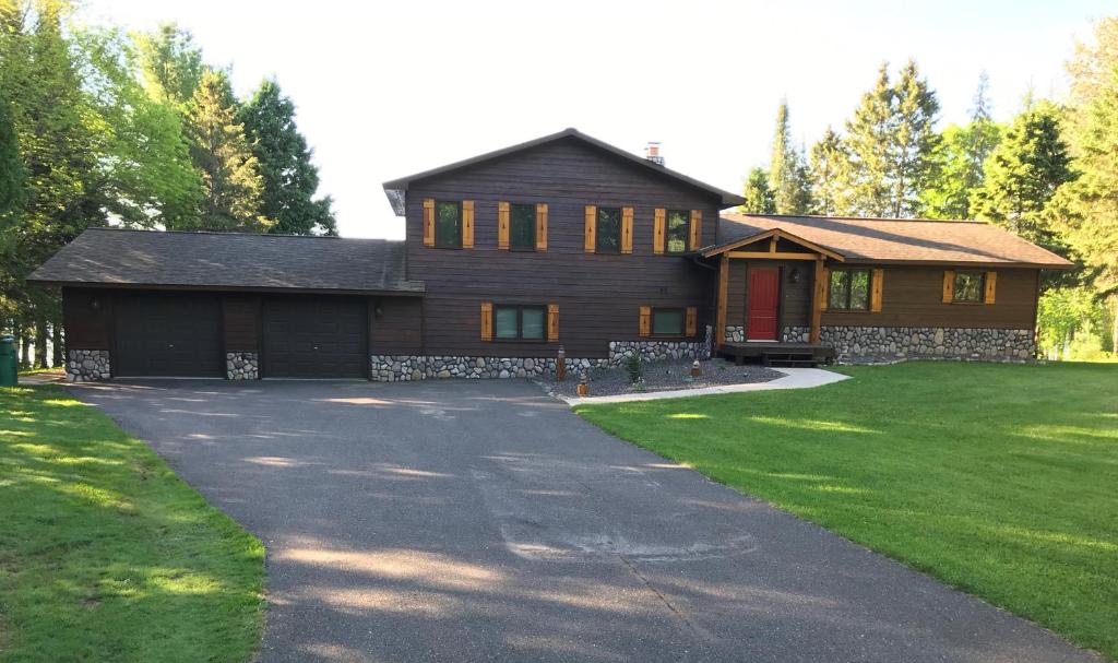 a large wooden house with a driveway at Peace Of Mind On Namakagon Condo in Namekagon