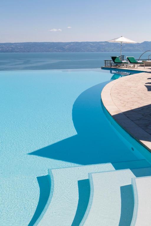 a swimming pool with a view of the water at Hôtel Royal in Évian-les-Bains