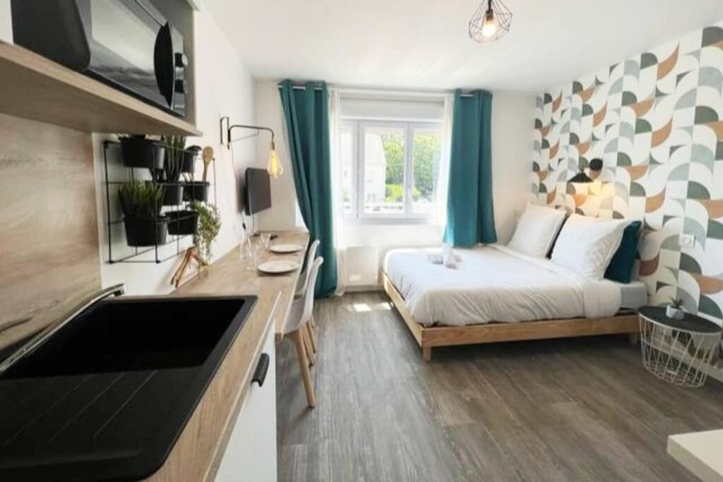 Il comprend une chambre avec un lit et une cuisine avec un évier. dans l'établissement Suite Le studio KIWI, lumineux proche des plages, à Saint-Nazaire