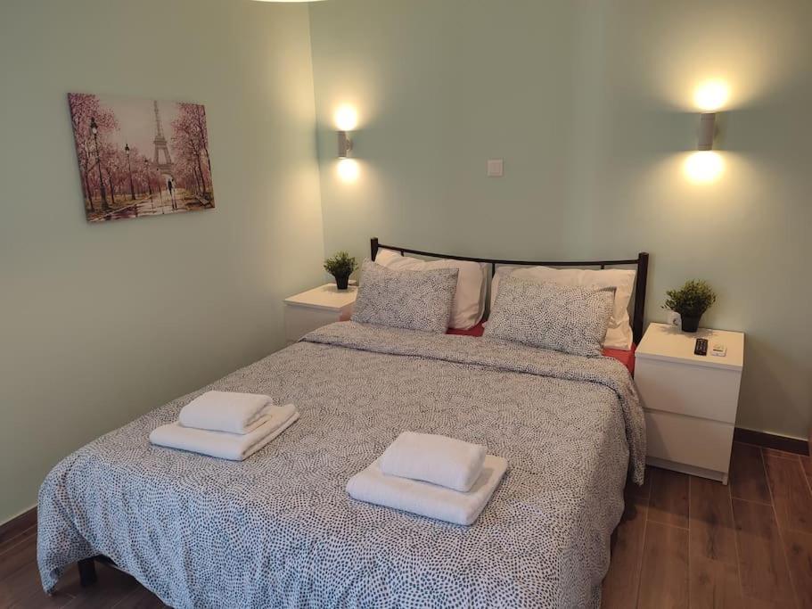1 dormitorio con 1 cama con 2 toallas en Penthouse in the centre of Ilion Athens, en Atenas