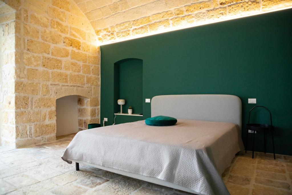 - une chambre dotée d'un lit avec un mur vert dans l'établissement Aqua - Letto e Colazione, à Acquaviva delle Fonti