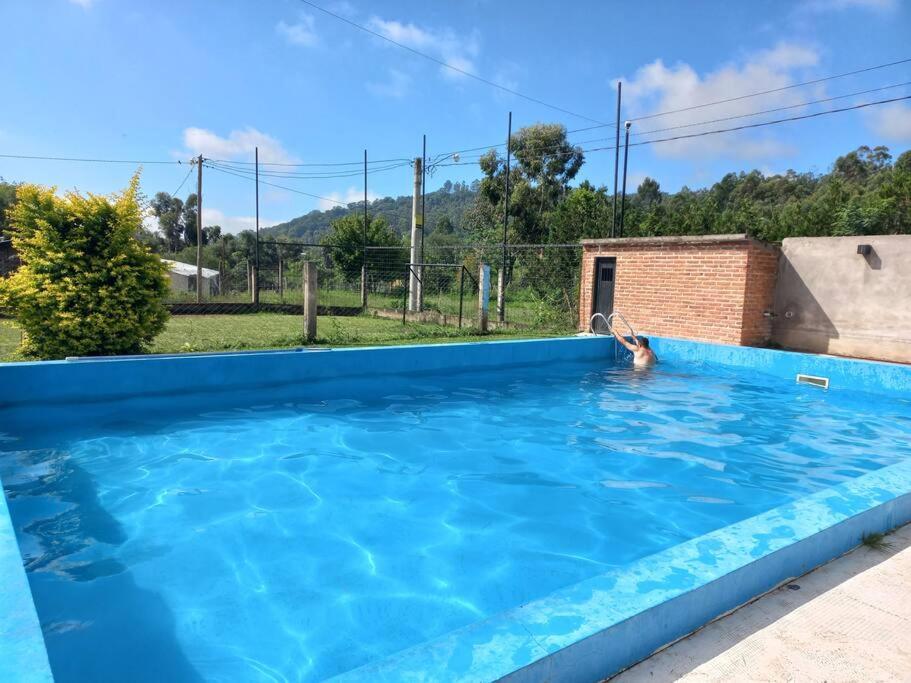 een persoon die zwemt in een groot blauw zwembad bij EL ESTABLO - Casa de Campo Vacacional con pileta privada - Jujuy in San Salvador de Jujuy
