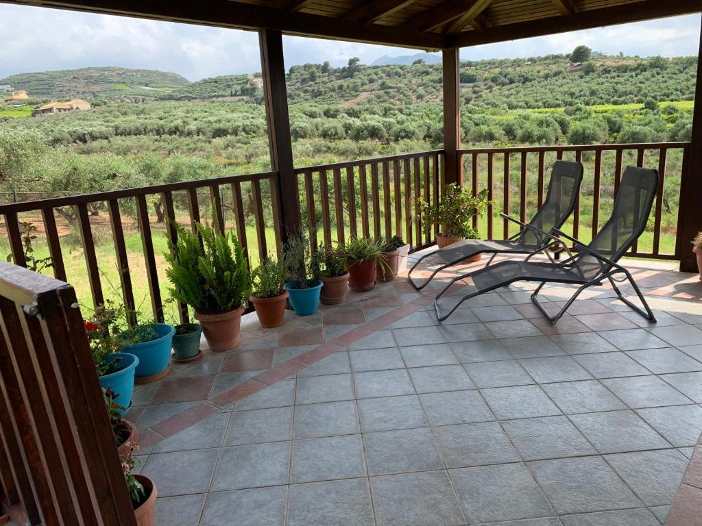 un porche con dos sillas y macetas. en Eden Garden Villa en Skalánion