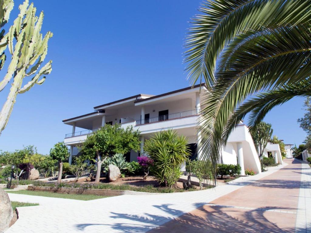 un bâtiment avec des palmiers en face de celui-ci dans l'établissement Nice residence in San Nicol di Ricadi with pool, à Ricadi